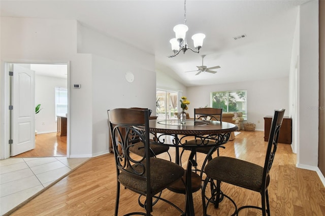 dining area featuring lofted ceiling, ceiling fan with notable chandelier, and light hardwood / wood-style flooring