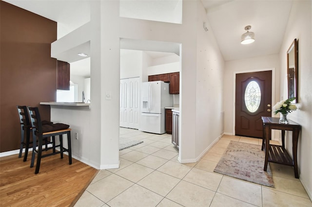 foyer with vaulted ceiling and light tile patterned floors