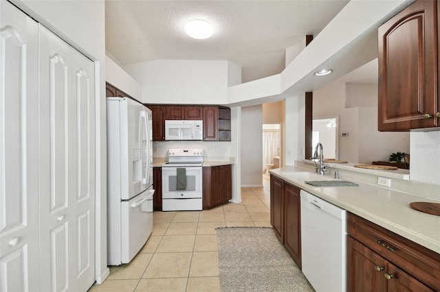 kitchen featuring vaulted ceiling, white appliances, light tile patterned flooring, a textured ceiling, and sink