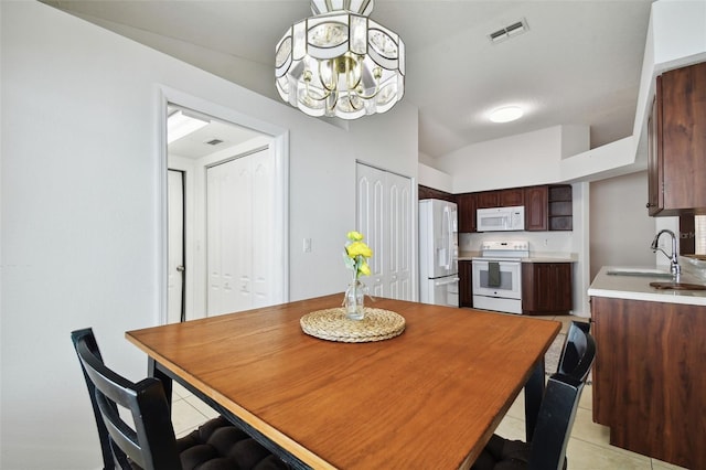 dining area featuring sink, a chandelier, and light tile patterned flooring