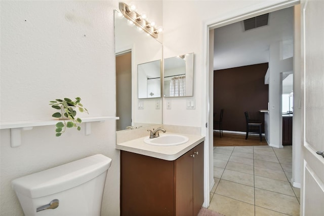 bathroom featuring toilet, vanity, and tile patterned flooring