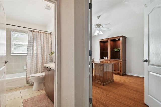 full bathroom featuring ceiling fan, vanity, toilet, tile patterned floors, and shower / bath combination with curtain