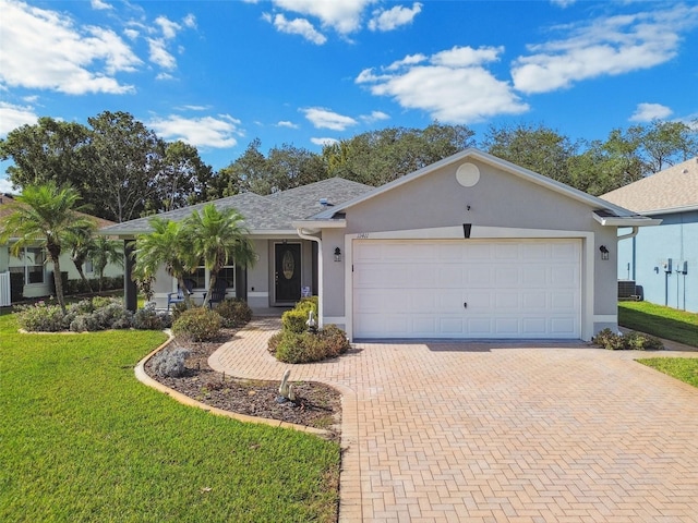 ranch-style house featuring a front lawn, a garage, and central AC