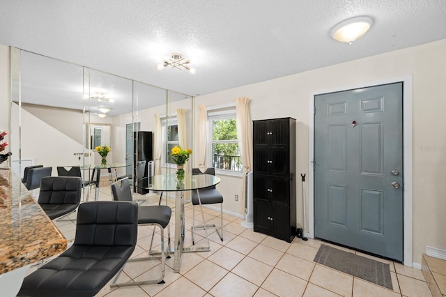 kitchen with light tile patterned floors, a textured ceiling, and decorative light fixtures