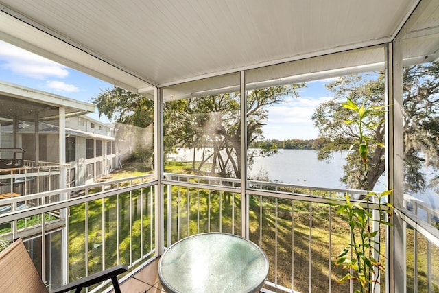 sunroom featuring plenty of natural light and a water view