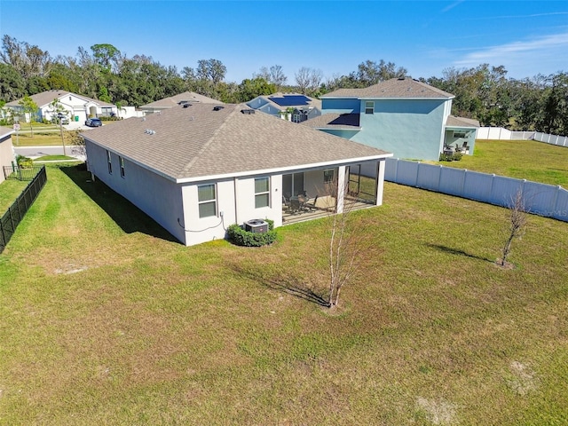 rear view of property with a sunroom, cooling unit, and a yard