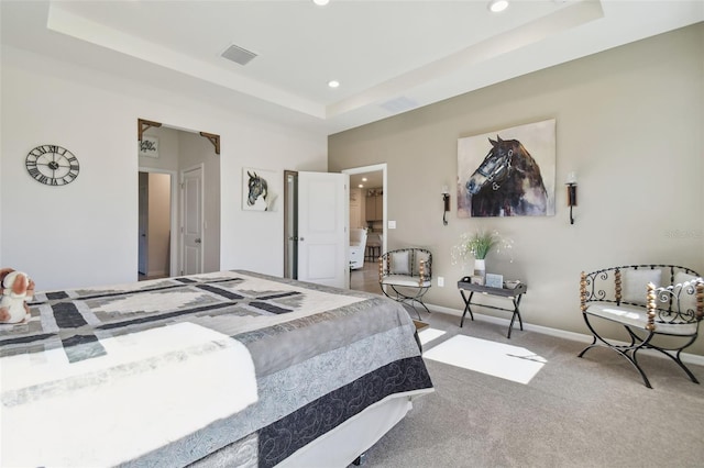 bedroom with carpet flooring and a tray ceiling