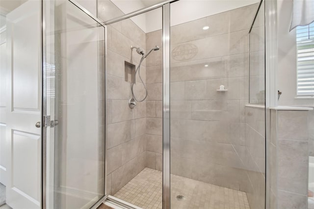 bathroom featuring a shower with shower door