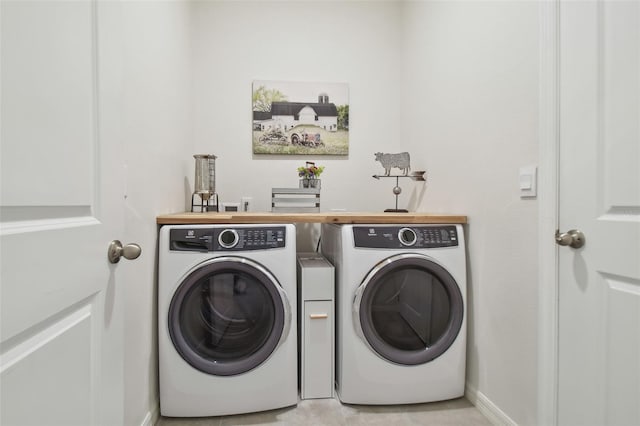 laundry room featuring washing machine and dryer and light tile patterned flooring