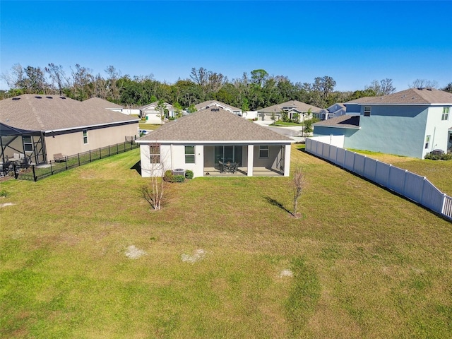 back of house with a sunroom and a yard