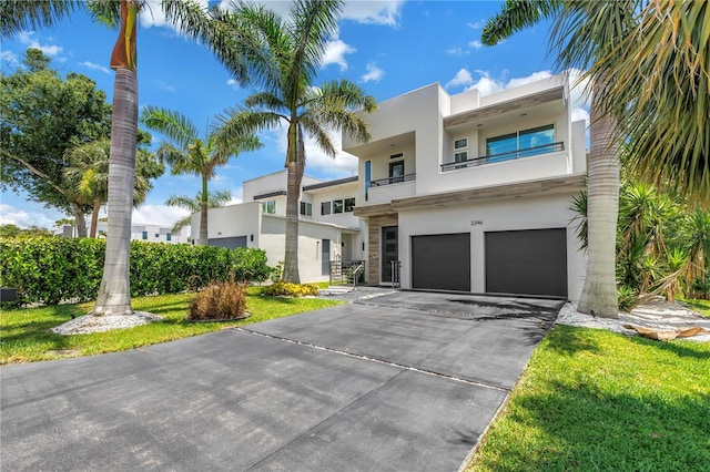 2246 Fiesta Dr, Sarasota, FL 34231 - view of front of home featuring stucco siding, an attached garage, driveway, and a balcony