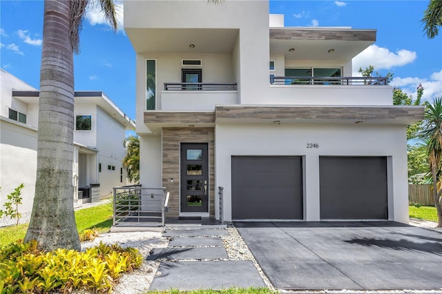 2246 Fiesta Dr, Sarasota, FL 34231 - modern home with an attached garage, a balcony, stucco siding, and driveway