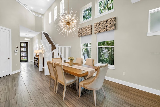 2246 Fiesta Dr, Sarasota, FL 34231 - dining area featuring a high ceiling, a chandelier, stairs, wood finished floors, and recessed lighting