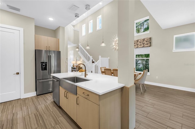 2246 Fiesta Dr, Sarasota, FL 34231 - kitchen featuring stainless steel appliances, a high ceiling, light countertops, a center island with sink, and plenty of natural light