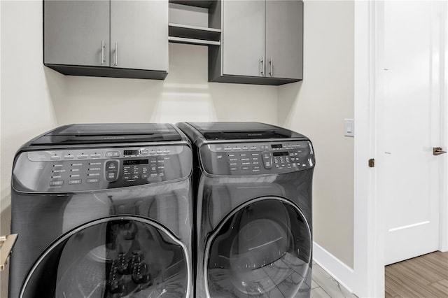 2246 Fiesta Dr, Sarasota, FL 34231 - laundry area with washer and dryer, cabinet space, and wood finished floors