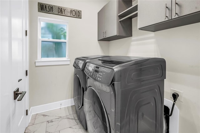 2246 Fiesta Dr, Sarasota, FL 34231 - laundry room featuring independent washer and dryer, cabinet space, and light marble finish flooring