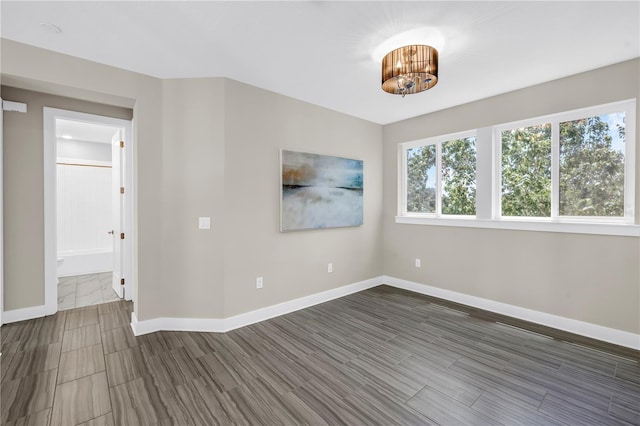 2246 Fiesta Dr, Sarasota, FL 34231 - unfurnished room with a chandelier and wood finish floors