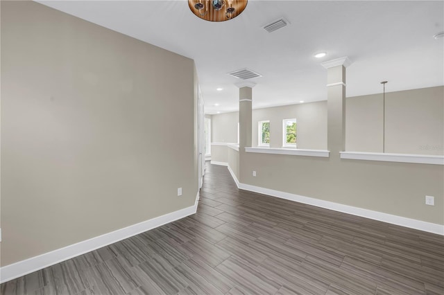 2246 Fiesta Dr, Sarasota, FL 34231 - spare room with decorative columns, wood finished floors, and recessed lighting