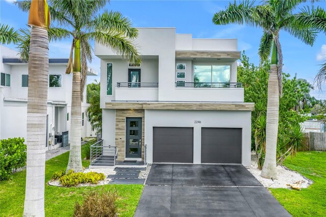 2246 Fiesta Dr, Sarasota, FL 34231 - contemporary house featuring an attached garage, a balcony, stucco siding, and concrete driveway