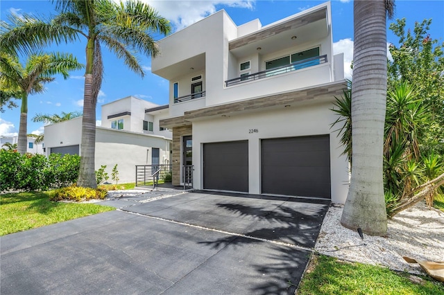 2246 Fiesta Dr, Sarasota, FL 34231 - contemporary house featuring a garage, stucco siding, driveway, and a balcony