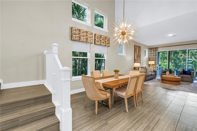 2246 Fiesta Dr, Sarasota, FL 34231 - dining area with a chandelier, wood finished floors, and a towering ceiling