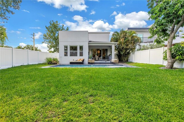 2246 Fiesta Dr, Sarasota, FL 34231 - rear view of house featuring a fenced backyard, an outdoor hangout area, and stucco siding