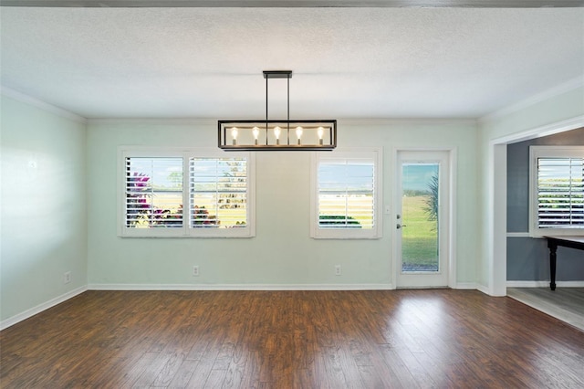 unfurnished dining area with crown molding, dark wood-type flooring, a textured ceiling, and an inviting chandelier