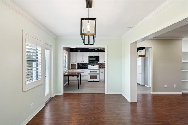 interior space featuring dark wood-type flooring, tasteful backsplash, pendant lighting, white appliances, and white cabinets