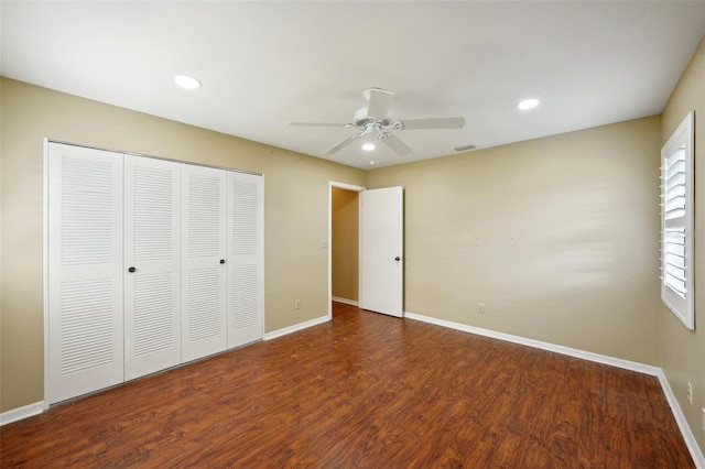 unfurnished bedroom with a closet, dark hardwood / wood-style floors, and ceiling fan