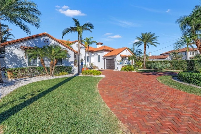 mediterranean / spanish-style house with a front yard and a garage