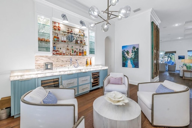 bar with tasteful backsplash, ornamental molding, dark wood-type flooring, decorative light fixtures, and wine cooler