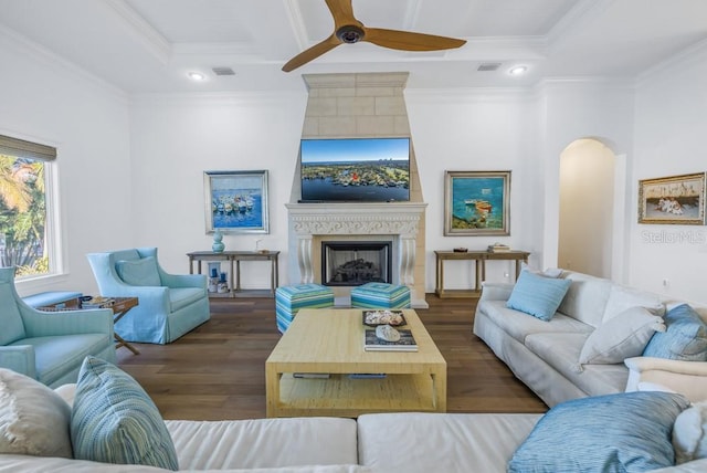 living room featuring crown molding, a fireplace, ceiling fan, and dark hardwood / wood-style floors