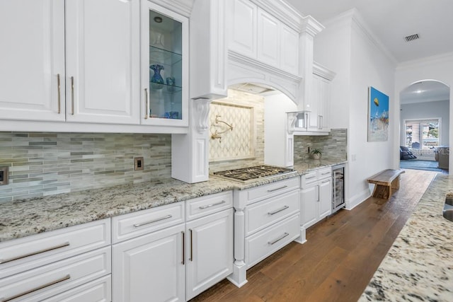 kitchen with stainless steel gas stovetop, dark wood-type flooring, white cabinets, wine cooler, and decorative backsplash