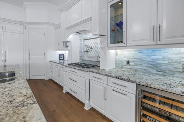 kitchen featuring wine cooler, white cabinetry, light stone countertops, and decorative backsplash