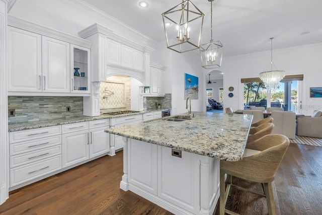 kitchen with decorative backsplash, decorative light fixtures, white cabinetry, and sink