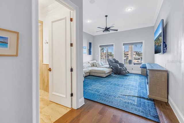 bedroom featuring hardwood / wood-style flooring, ceiling fan, and crown molding