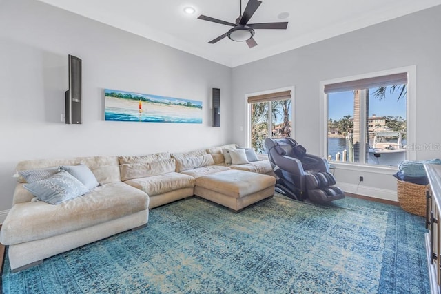 living room with wood-type flooring, a water view, and ceiling fan