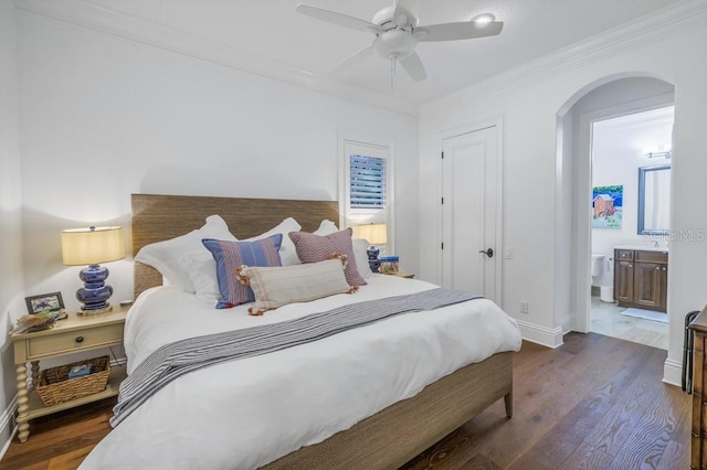 bedroom featuring ensuite bath, ceiling fan, dark hardwood / wood-style floors, and ornamental molding