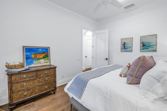 bedroom with ceiling fan, crown molding, and dark wood-type flooring