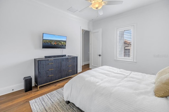 bedroom with dark hardwood / wood-style floors, ceiling fan, and ornamental molding