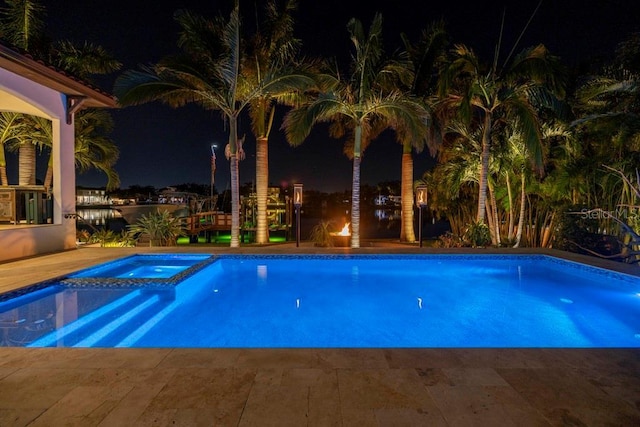 pool at twilight with an in ground hot tub