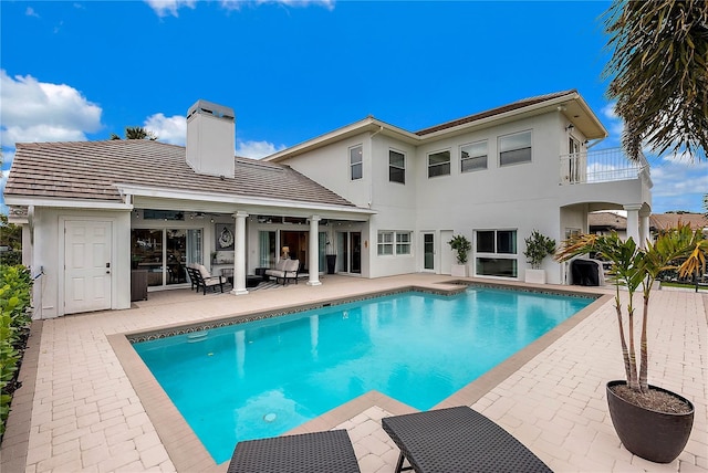 view of swimming pool with outdoor lounge area, ceiling fan, and a patio area