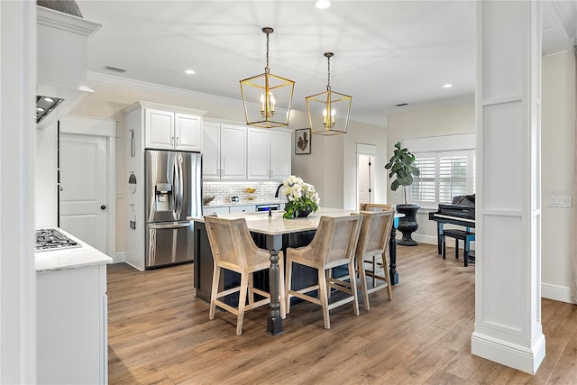 dining space featuring light hardwood / wood-style floors and ornamental molding