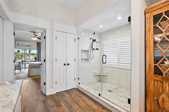 bathroom with ceiling fan, an enclosed shower, and wood-type flooring