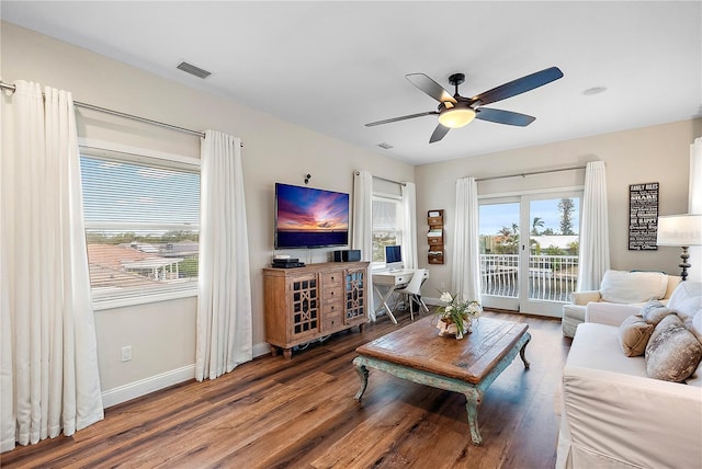 living room with ceiling fan and dark wood-type flooring