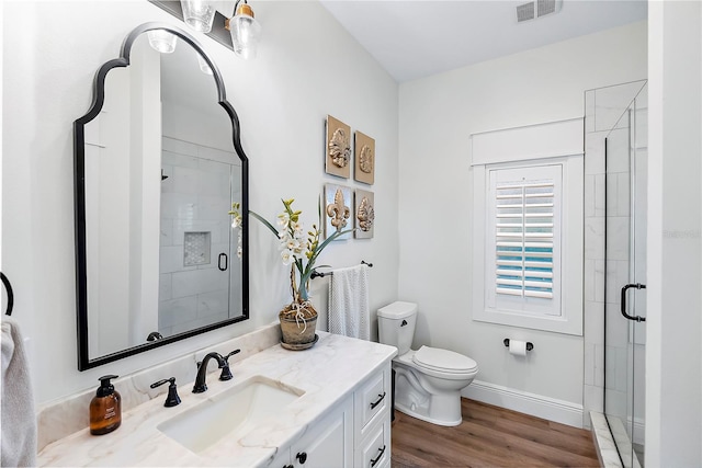 bathroom featuring vanity, wood-type flooring, an enclosed shower, and toilet