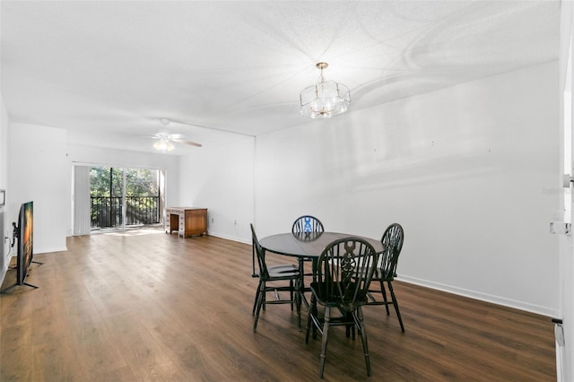 dining area featuring ceiling fan with notable chandelier and dark hardwood / wood-style floors