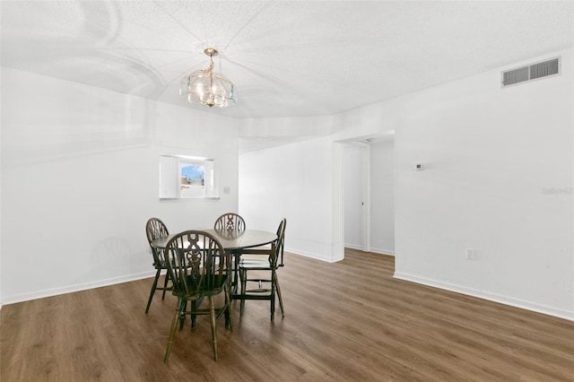 dining area with dark hardwood / wood-style floors and a chandelier