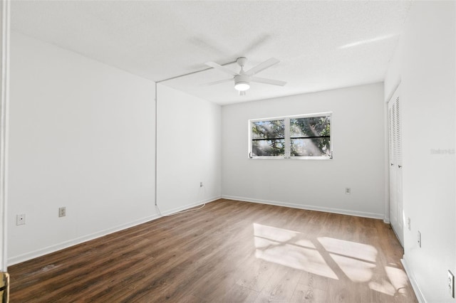 spare room featuring a textured ceiling, ceiling fan, and dark hardwood / wood-style floors