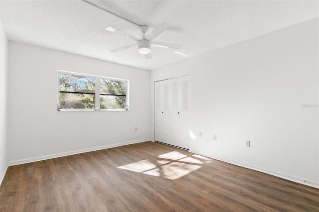 spare room with a textured ceiling, dark hardwood / wood-style floors, and ceiling fan